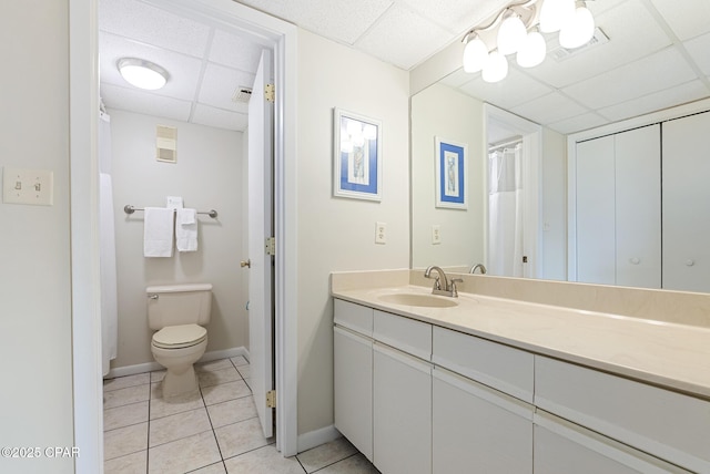 full bathroom featuring a paneled ceiling, tile patterned floors, toilet, vanity, and baseboards