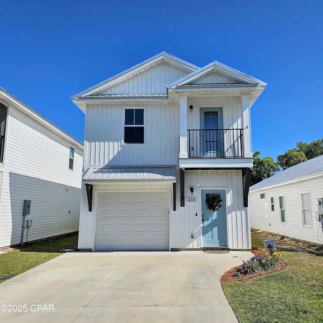 view of front of home with a garage, a balcony, driveway, board and batten siding, and metal roof