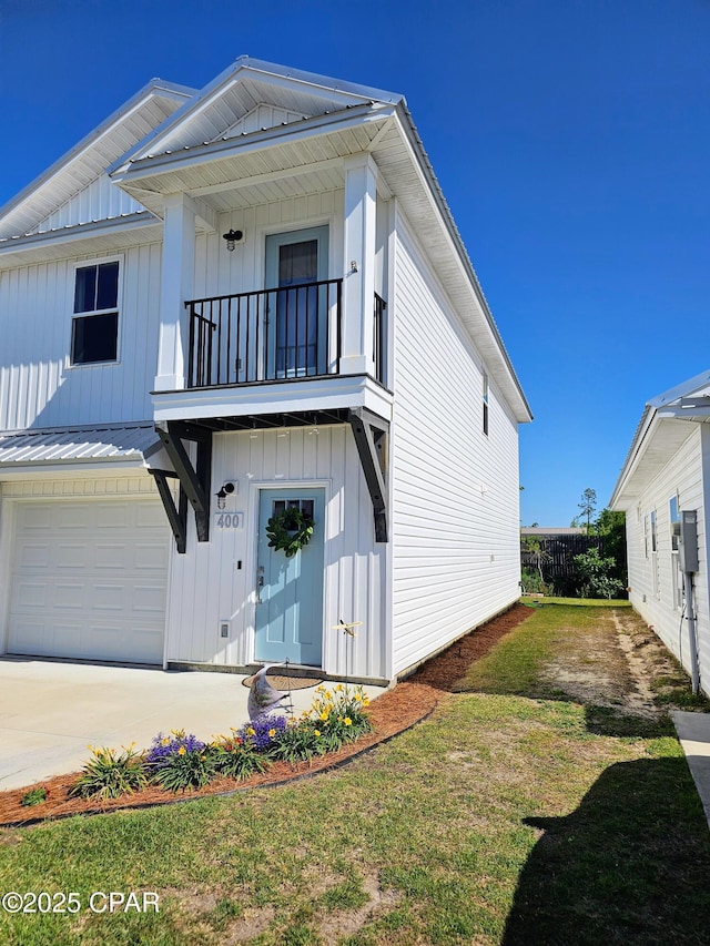 view of front of property featuring a front lawn, a balcony, concrete driveway, board and batten siding, and a garage