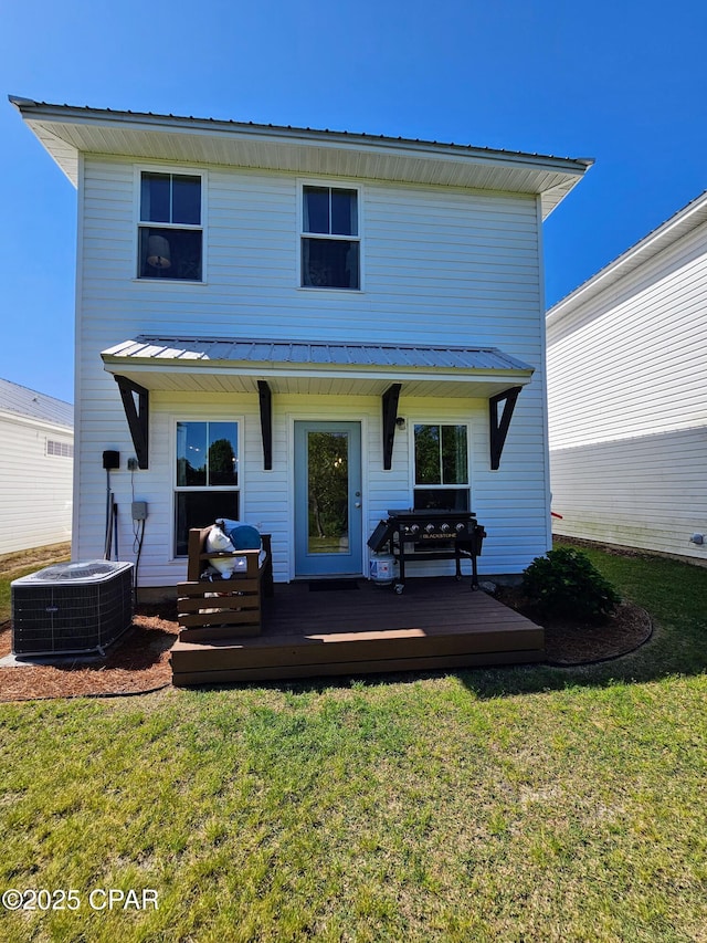 back of property with central air condition unit, a wooden deck, a yard, and metal roof