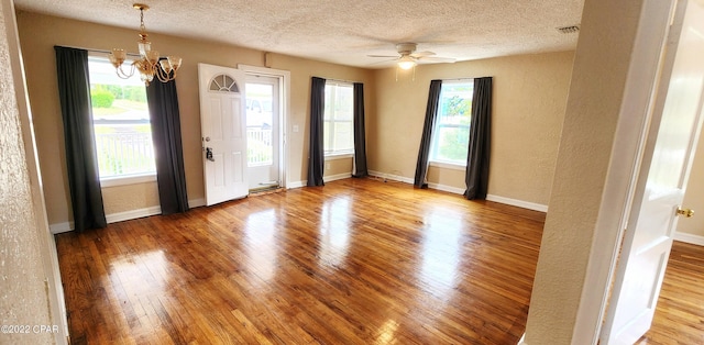 entryway featuring a healthy amount of sunlight, wood finished floors, a textured ceiling, and visible vents