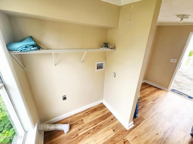 laundry area with hookup for an electric dryer, light wood-type flooring, baseboards, laundry area, and washer hookup