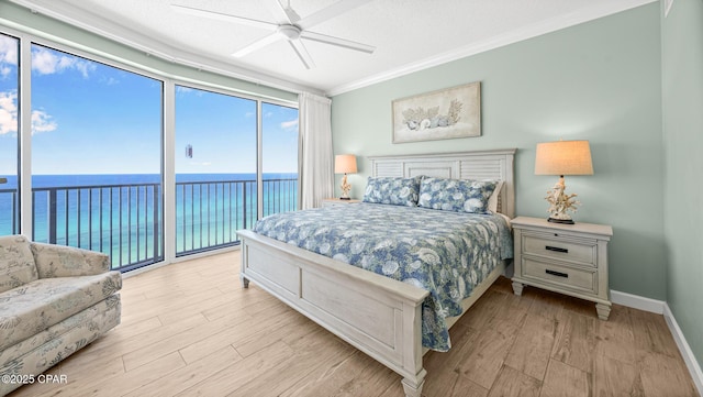 9450 S Thomas Dr Unit 1609C, Panama City Beach, FL 32408 - bedroom featuring access to exterior, a water view, light wood-style flooring, ornamental molding, and baseboards