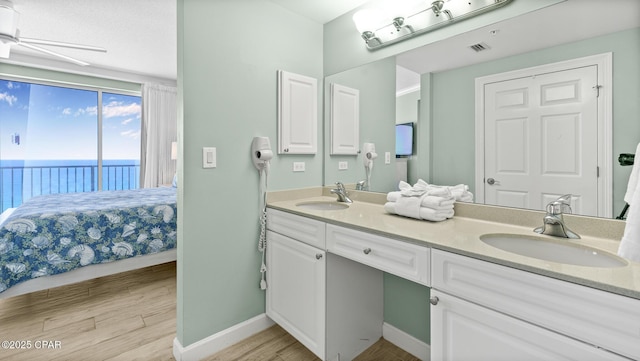 9450 S Thomas Dr Unit 1609C, Panama City Beach, FL 32408 - ensuite bathroom with wood finished floors, double vanity, a water view, and baseboards