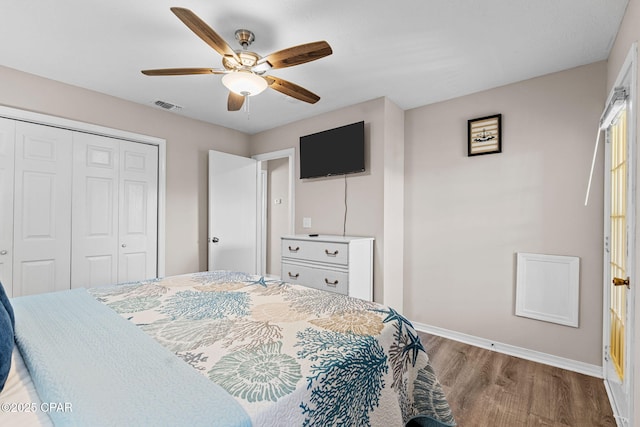 bedroom featuring a closet, ceiling fan, visible vents, baseboards, and wood finished floors