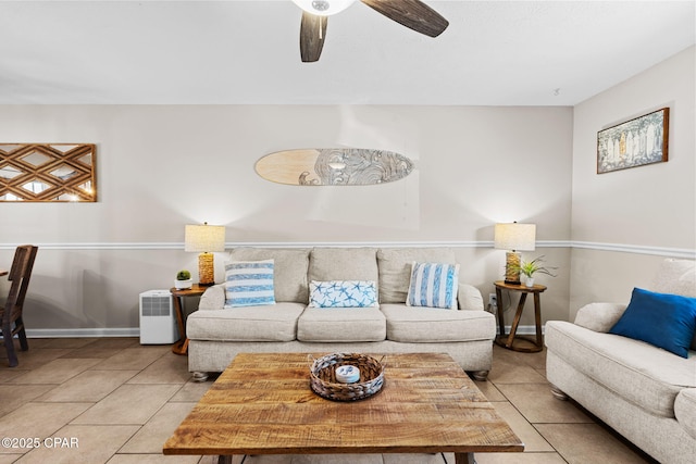 living area featuring a ceiling fan, tile patterned floors, and baseboards
