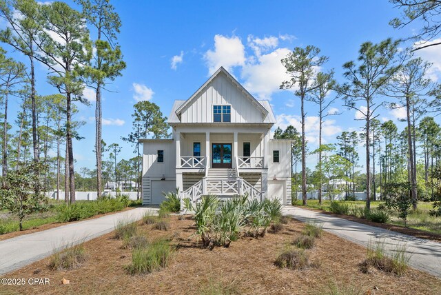 205 Mallard Ln, Santa Rosa Beach, FL 32459 - raised beach house with board and batten siding, covered porch, stairs, and concrete driveway