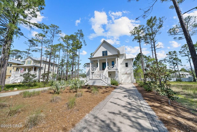 205 Mallard Ln, Santa Rosa Beach, FL 32459 - view of front of property with stairway, an attached garage, board and batten siding, driveway, and a porch