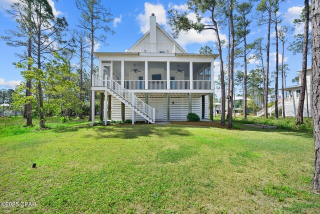 205 Mallard Ln, Santa Rosa Beach, FL 32459 - back of property with stairway, a lawn, a ceiling fan, and a sunroom