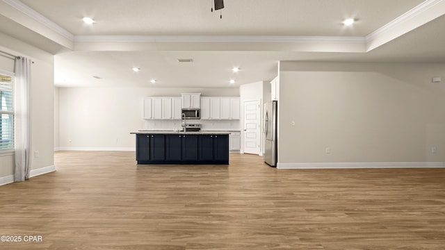 4744 Rosemary St, Panama City, FL 32404 - kitchen with crown molding, open floor plan, white cabinetry, light wood-style flooring, and appliances with stainless steel finishes