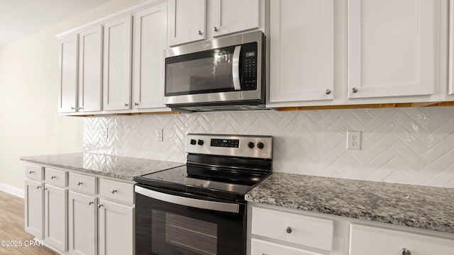 4744 Rosemary St, Panama City, FL 32404 - kitchen with white cabinets, stainless steel appliances, and light stone counters