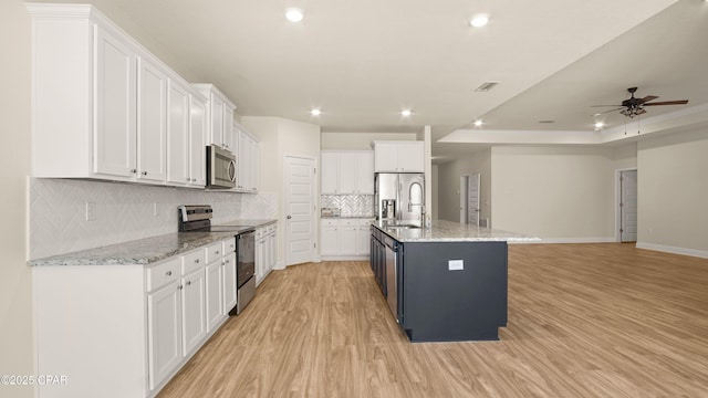 4744 Rosemary St, Panama City, FL 32404 - kitchen featuring white cabinets, stainless steel appliances, tasteful backsplash, light wood-type flooring, and ceiling fan