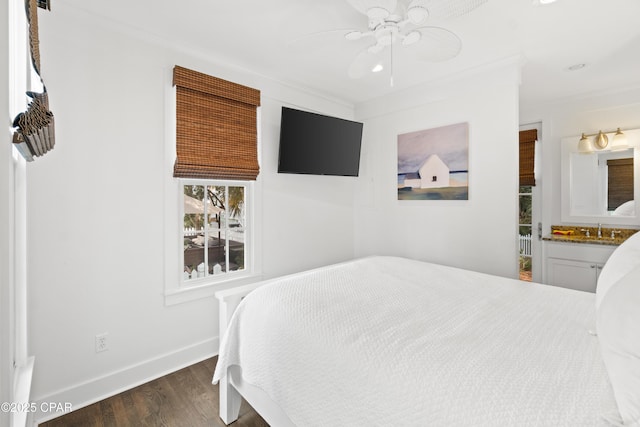 bedroom with crown molding, baseboards, a sink, and dark wood-type flooring