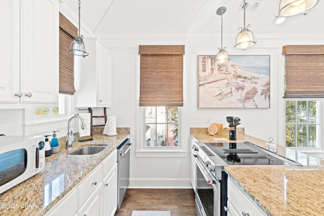 kitchen featuring white cabinets, a sink, stainless steel appliances, baseboards, and dark wood-style floors