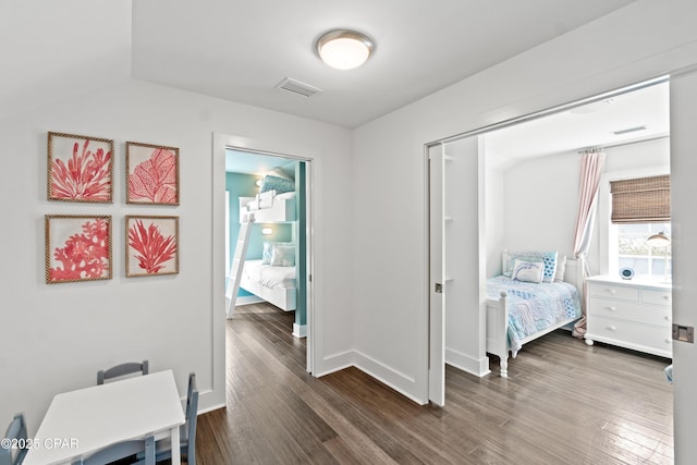 bedroom featuring baseboards, visible vents, and dark wood finished floors