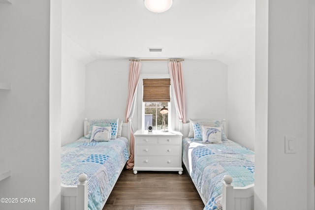 bedroom featuring visible vents, vaulted ceiling, and dark wood-type flooring