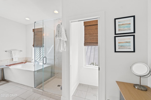 bathroom featuring recessed lighting, a freestanding tub, a shower stall, and marble finish floor