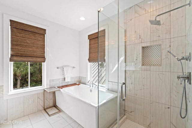 bathroom featuring a freestanding bath, tile walls, and a stall shower