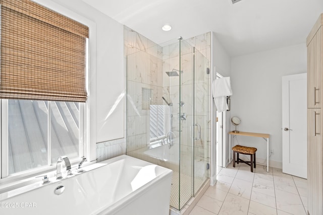 bathroom with a freestanding bath, a shower stall, a sink, and marble finish floor