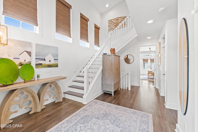 entryway featuring stairs, wood finished floors, and a wealth of natural light