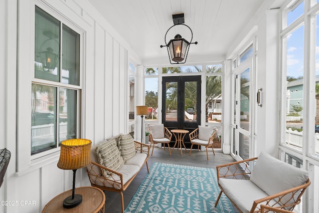 sunroom / solarium with ornamental molding, french doors, and wood finished floors