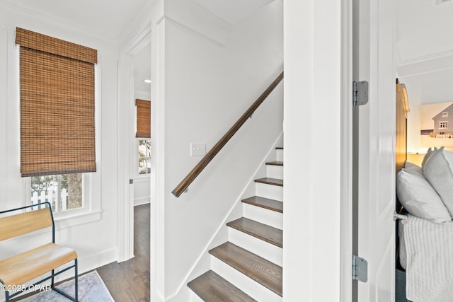 staircase featuring baseboards and wood finished floors