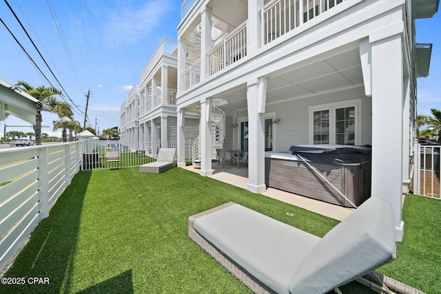 exterior space with a fenced backyard, a yard, a hot tub, and a patio