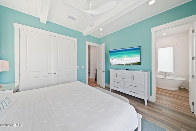 bedroom with beam ceiling, visible vents, recessed lighting, wood finished floors, and a closet