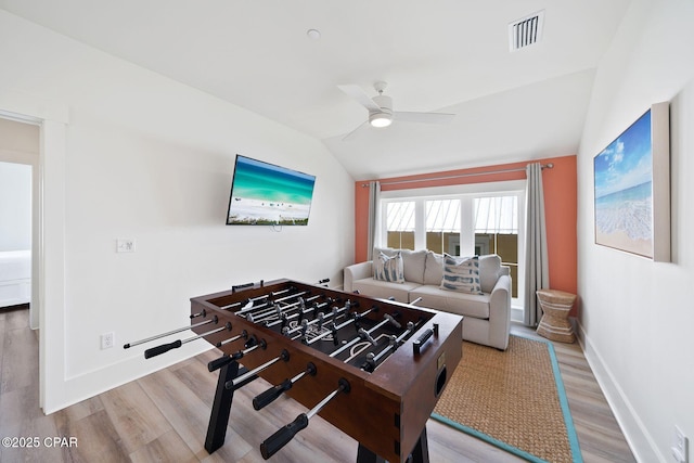 playroom featuring baseboards, visible vents, lofted ceiling, wood finished floors, and ceiling fan