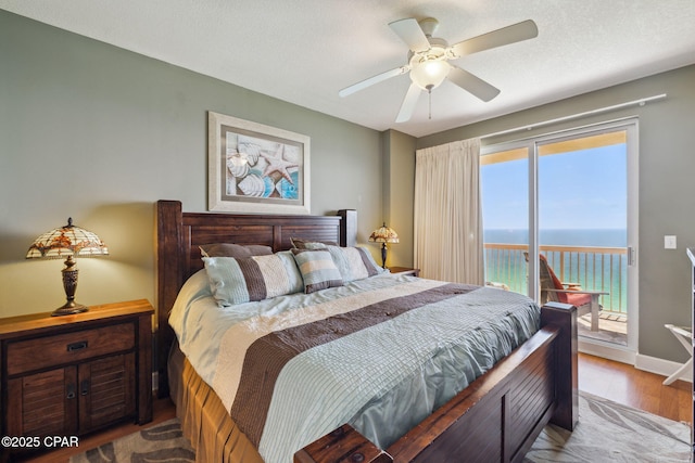 14825 Front Beach Rd Unit 2205, Panama City Beach, FL 32413 - bedroom with a water view, wood finished floors, access to exterior, baseboards, and ceiling fan