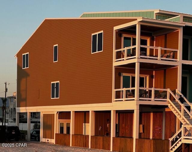 back of house with stairs and a balcony
