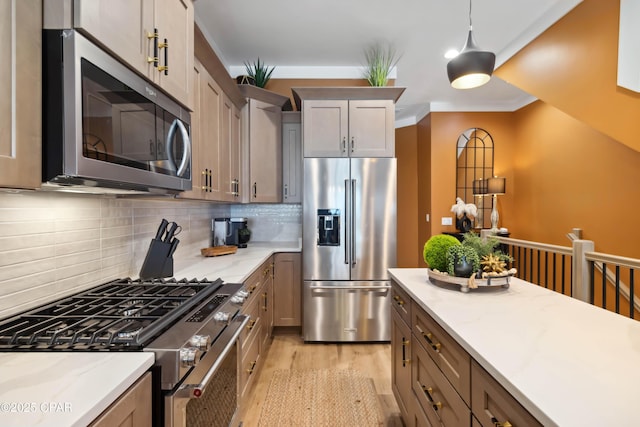 kitchen with light wood finished floors, backsplash, pendant lighting, light stone counters, and appliances with stainless steel finishes
