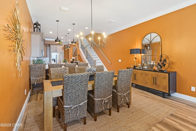 dining room with baseboards, a chandelier, light wood finished floors, and recessed lighting