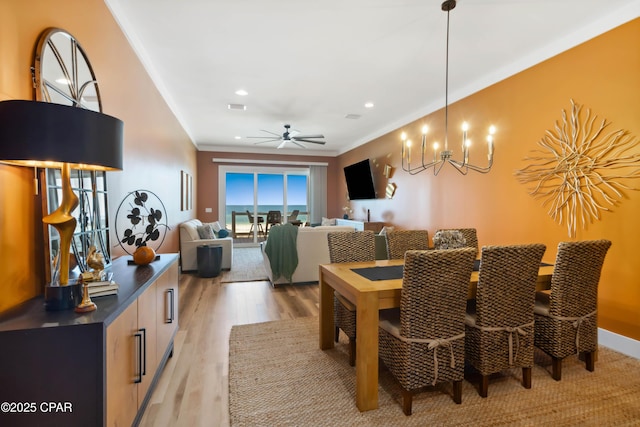 dining space with light wood-type flooring, recessed lighting, ornamental molding, and ceiling fan with notable chandelier