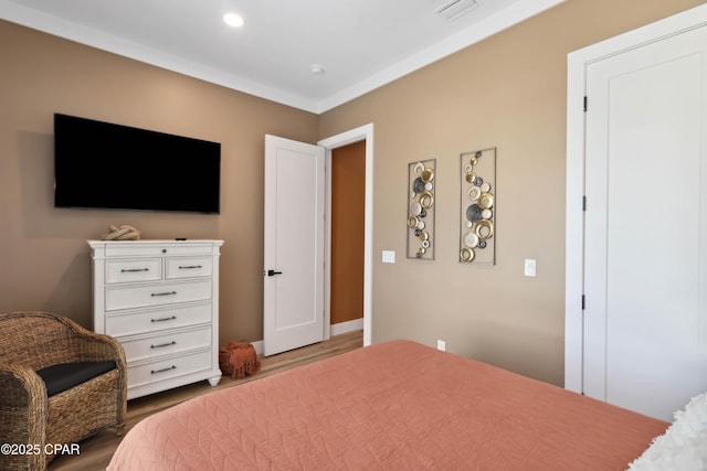 bedroom featuring wood finished floors, visible vents, and recessed lighting