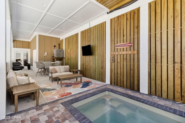 view of swimming pool featuring an outdoor living space, an indoor in ground hot tub, french doors, and a patio
