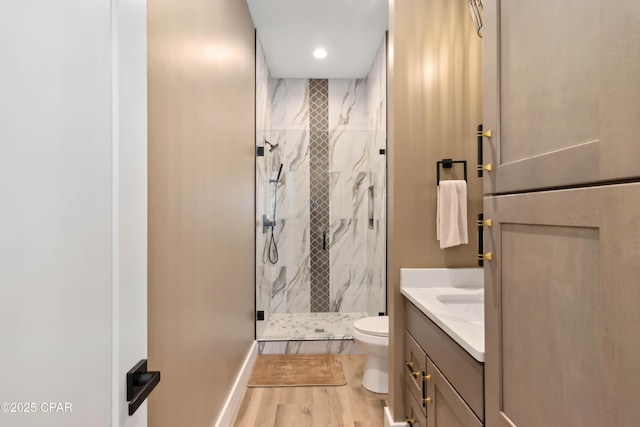 full bath featuring wood finished floors, a marble finish shower, vanity, toilet, and recessed lighting