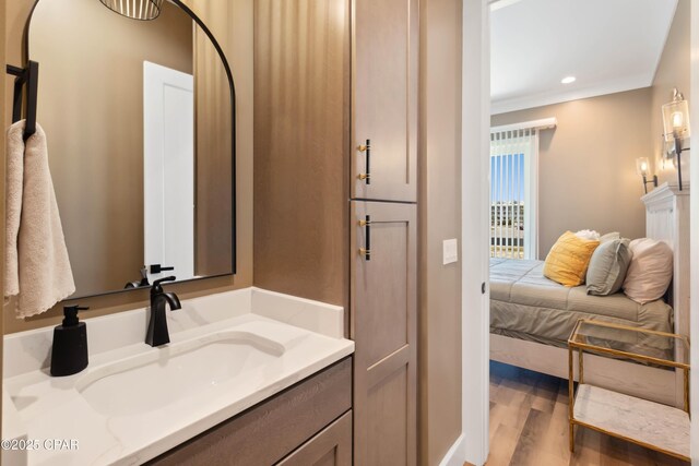 bathroom featuring wood finished floors, recessed lighting, and vanity