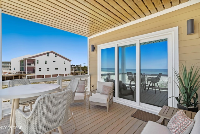 balcony with outdoor dining space and a water view