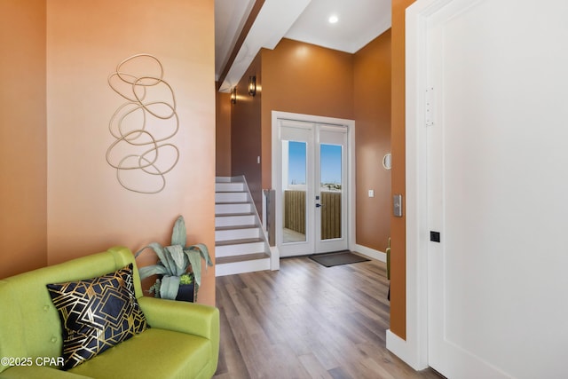 foyer featuring recessed lighting, wood finished floors, beamed ceiling, baseboards, and stairs