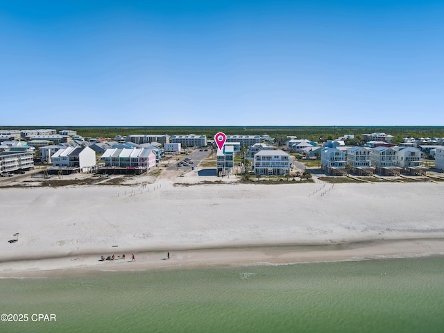 birds eye view of property featuring a beach view and a water view