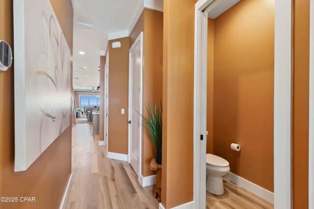 corridor with recessed lighting, light wood-style floors, and baseboards