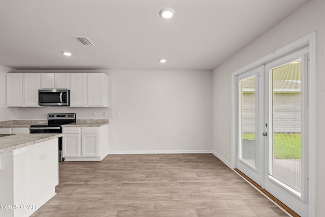 kitchen featuring visible vents, white cabinetry, light wood-style floors, and stainless steel appliances