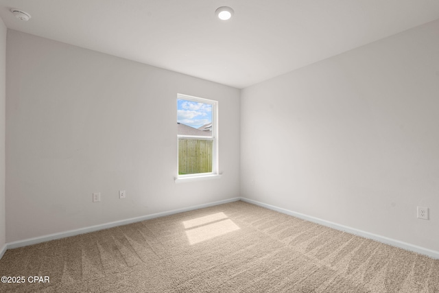 unfurnished room with baseboards and carpet