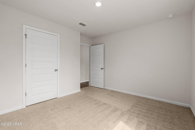 unfurnished bedroom with carpet floors, baseboards, and visible vents