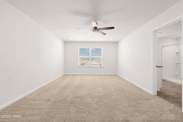 carpeted empty room featuring baseboards and ceiling fan