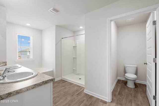 full bathroom featuring toilet, walk in shower, a sink, and wood finished floors