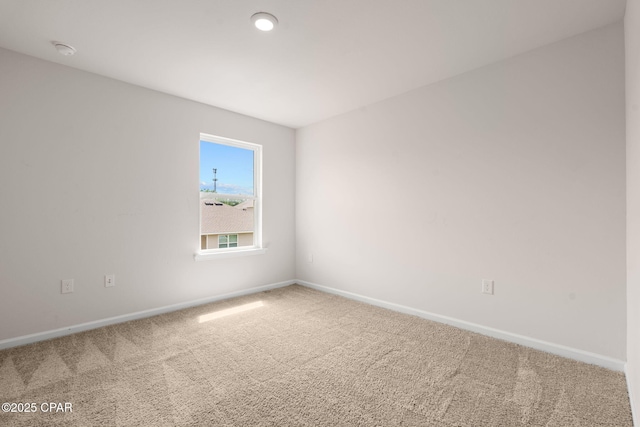 empty room featuring baseboards and carpet flooring