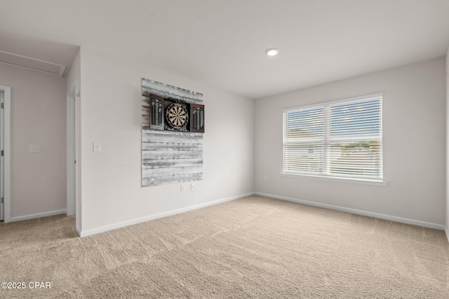 carpeted empty room featuring baseboards