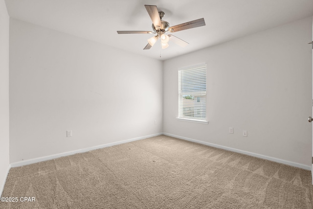 carpeted spare room featuring baseboards and ceiling fan